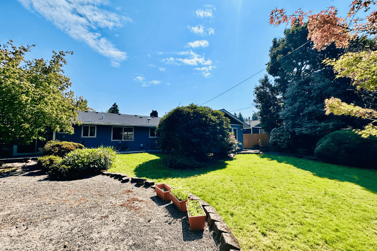 Expansive backyard with open lawn and greenery, offering a safe and tranquil environment for outdoor activities.