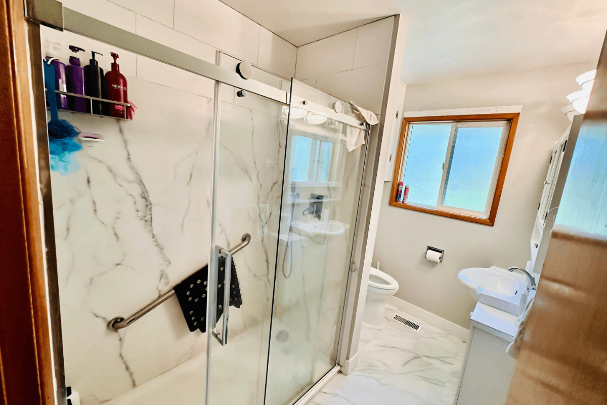 Clean and accessible bathroom with walk-in shower and safety features.